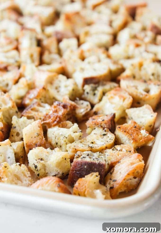 Golden Crispy Bread Bites 3 Close-up of cubed bread tossed with olive oil and spices, ready for baking into homemade croutons.