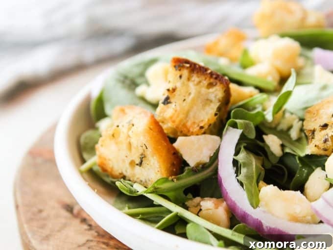 Golden Crispy Bread Bites 6 A bowl of homemade croutons with a wooden spoon, ready to be served or stored.