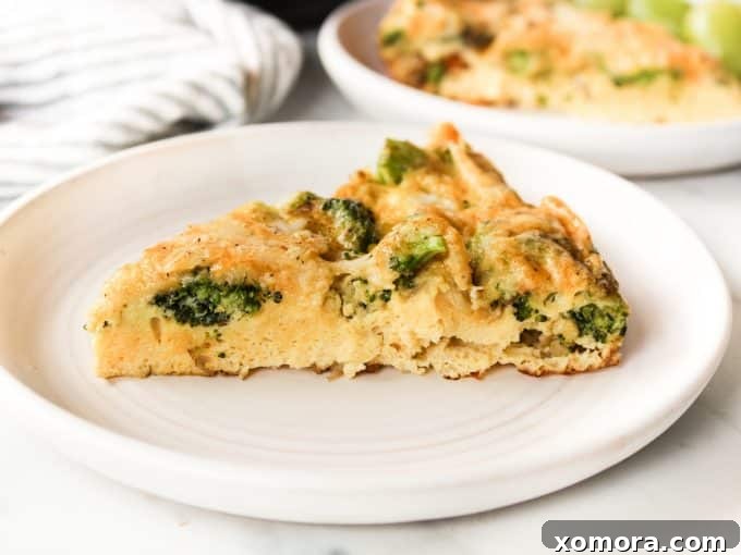 Fluffy Broccoli Cheddar Frittata 4 A golden-brown Broccoli Cheddar Frittata freshly baked in a cast iron skillet, ready to be sliced and served.