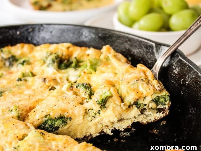 Fluffy Broccoli Cheddar Frittata 5 A close-up of a frittata slice with visible broccoli florets and melted cheddar, ready to be enjoyed.