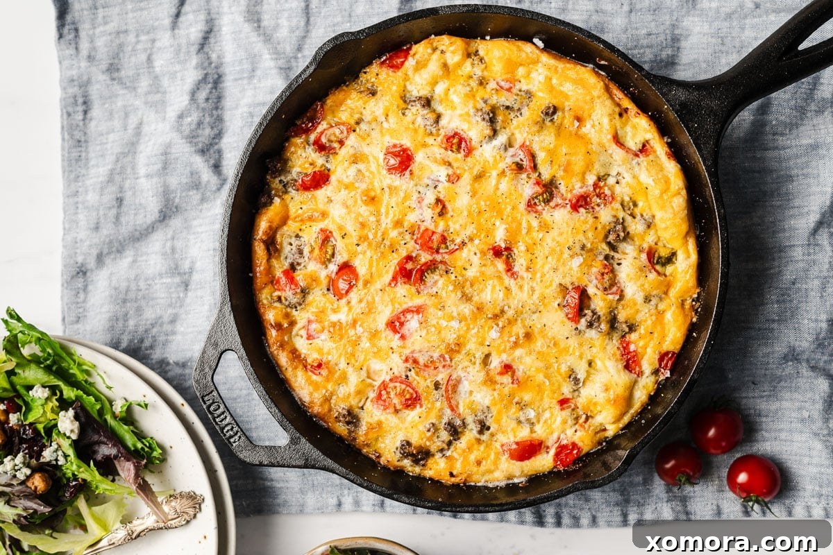 Cheeseburger Egg Bake 5 A freshly baked Cheeseburger Frittata in a cast iron skillet, garnished and ready to be sliced and served