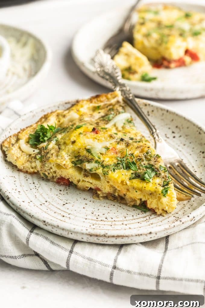 Golden Parmesan Herb Frittata 2 A slice of fluffy Parmesan Herb Frittata with a side of crispy potatoes and a fresh green salad.