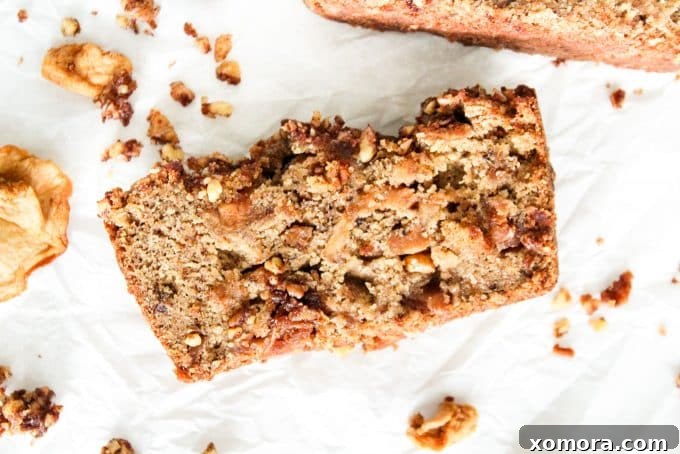 Rustic Gluten-Free Apple Walnut Streusel Bread 5 A hand sprinkling walnut crumble over the Gluten-Free Apple Bread batter in a loaf pan