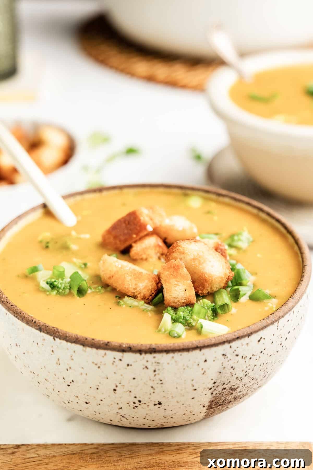 Creamy Dairy Free Broccoli Cheddar Soup 5 A close-up of a bowl of dairy-free broccoli cheese soup, showing its creamy texture and fresh broccoli florets.