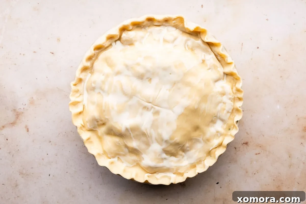 Effortless Homemade Chicken Pot Pie with Store-Bought Crust 6 A rolled refrigerated pie crust ready to be placed over a pie dish.
