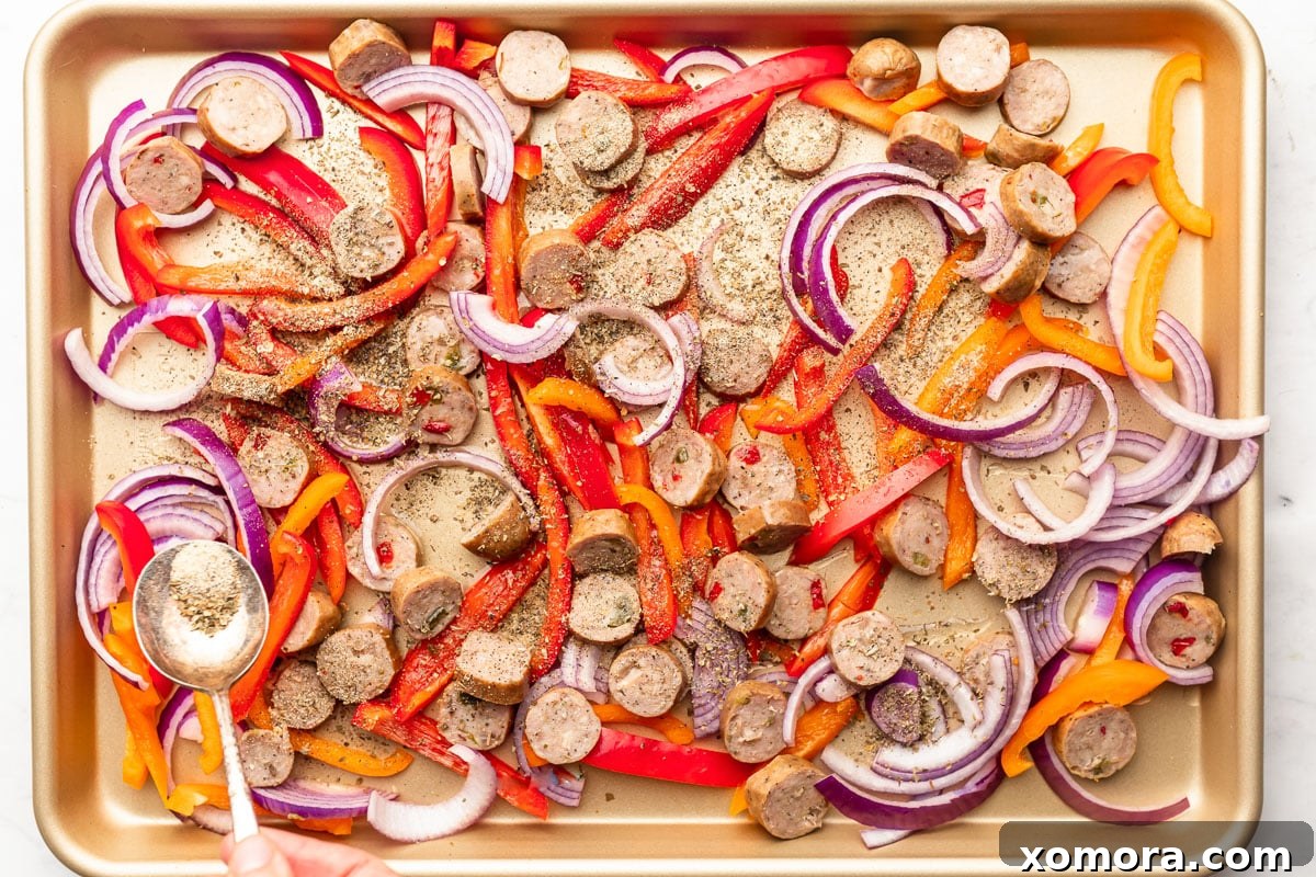 Effortless Roasted Italian Sausage and Peppers 4 The sausage and pepper mixture spread out on a baking sheet, ready for the oven.