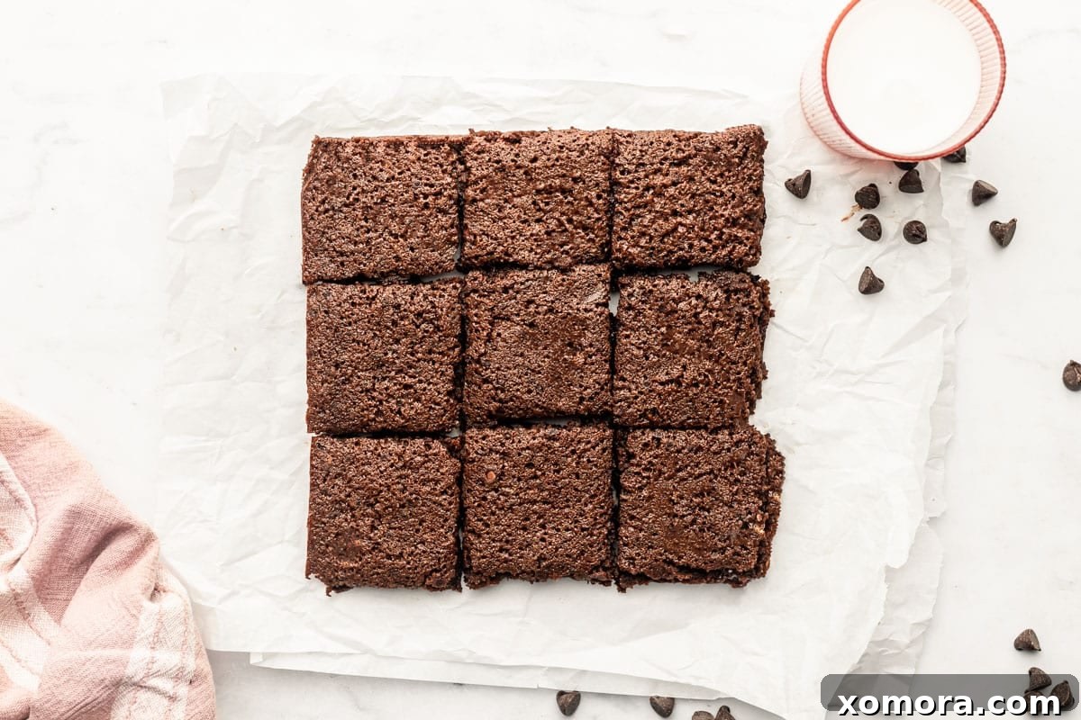 Fudgy Grain Free One Bowl Brownies 3 Ingredients for grain-free brownies laid out on a kitchen counter, showing paleo flour, cocoa, eggs, and sweeteners.
