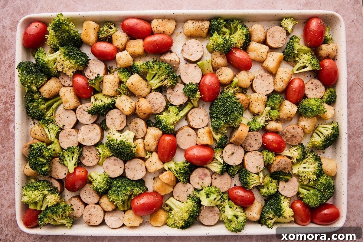 Cauliflower Gnocchi & Sausage Bake 4 Ingredients for baked cauliflower gnocchi with sausage laid out on a baking sheet before roasting.