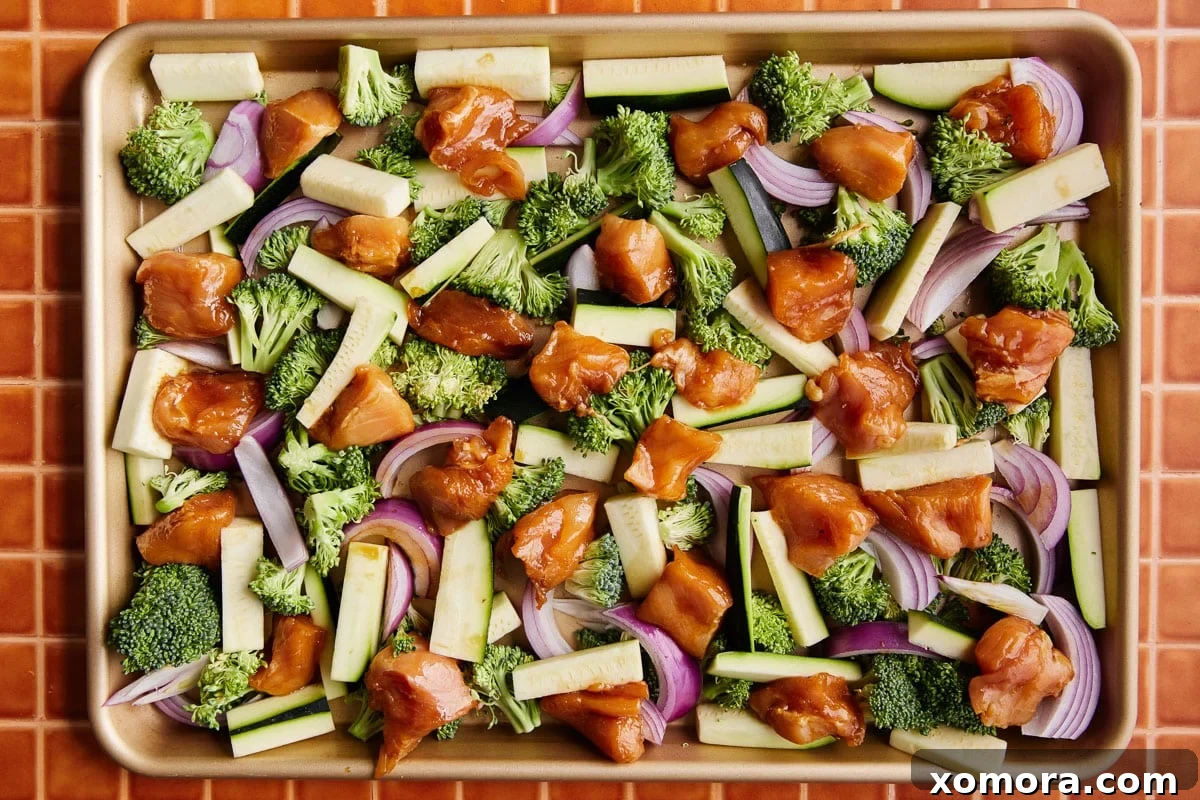 Sheet Pan Roasted Chicken and Seasonal Vegetables 4 Ingredients for chicken and vegetables laid out, including chicken, broccoli, zucchini, red onion, and various marinade components.