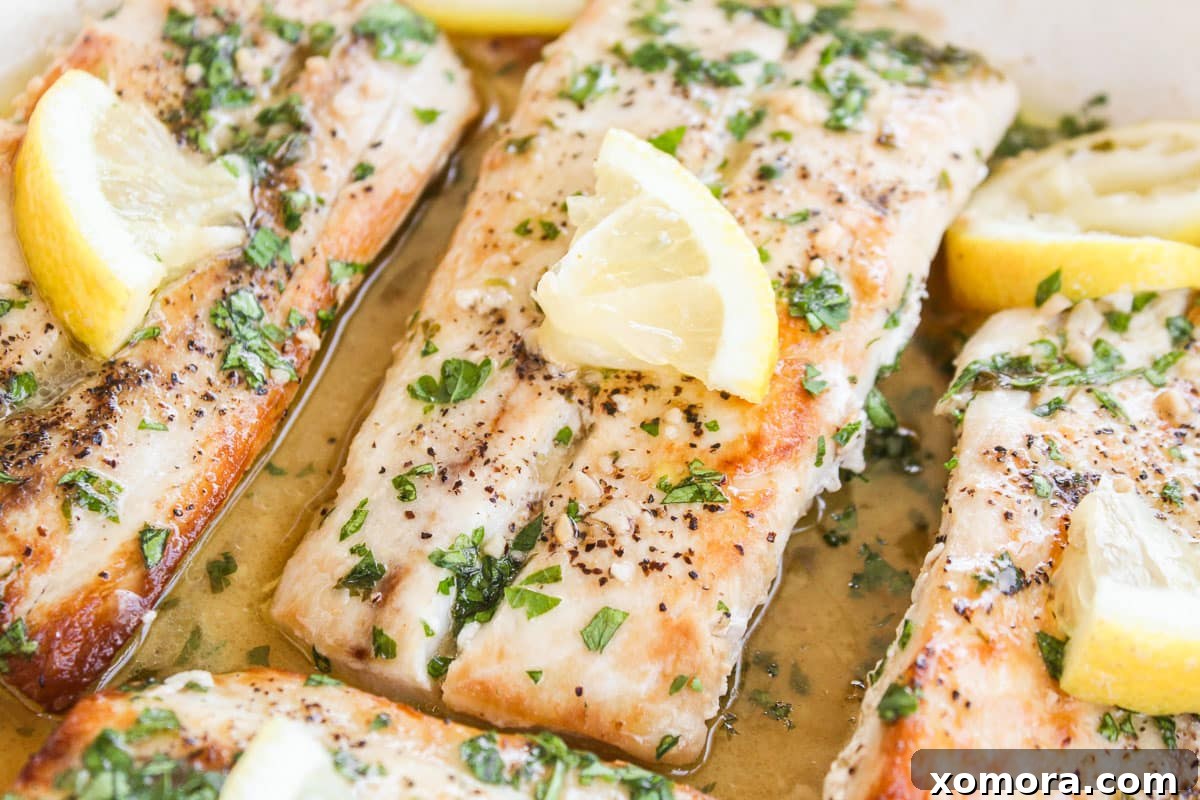 up close shot of mahi mahi topped with lemon in a skillet
