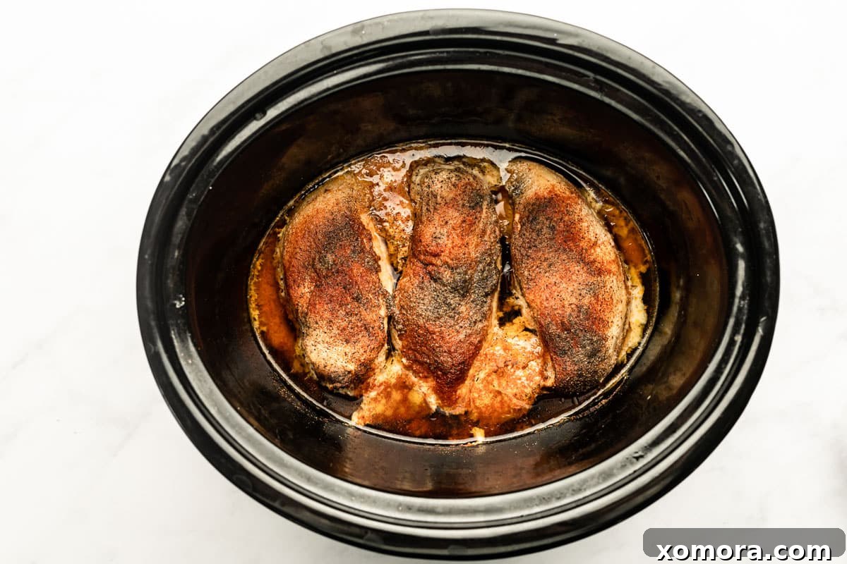 Effortless Slow Cooker Pulled Chicken 4 Cooked chicken breasts in a slow cooker