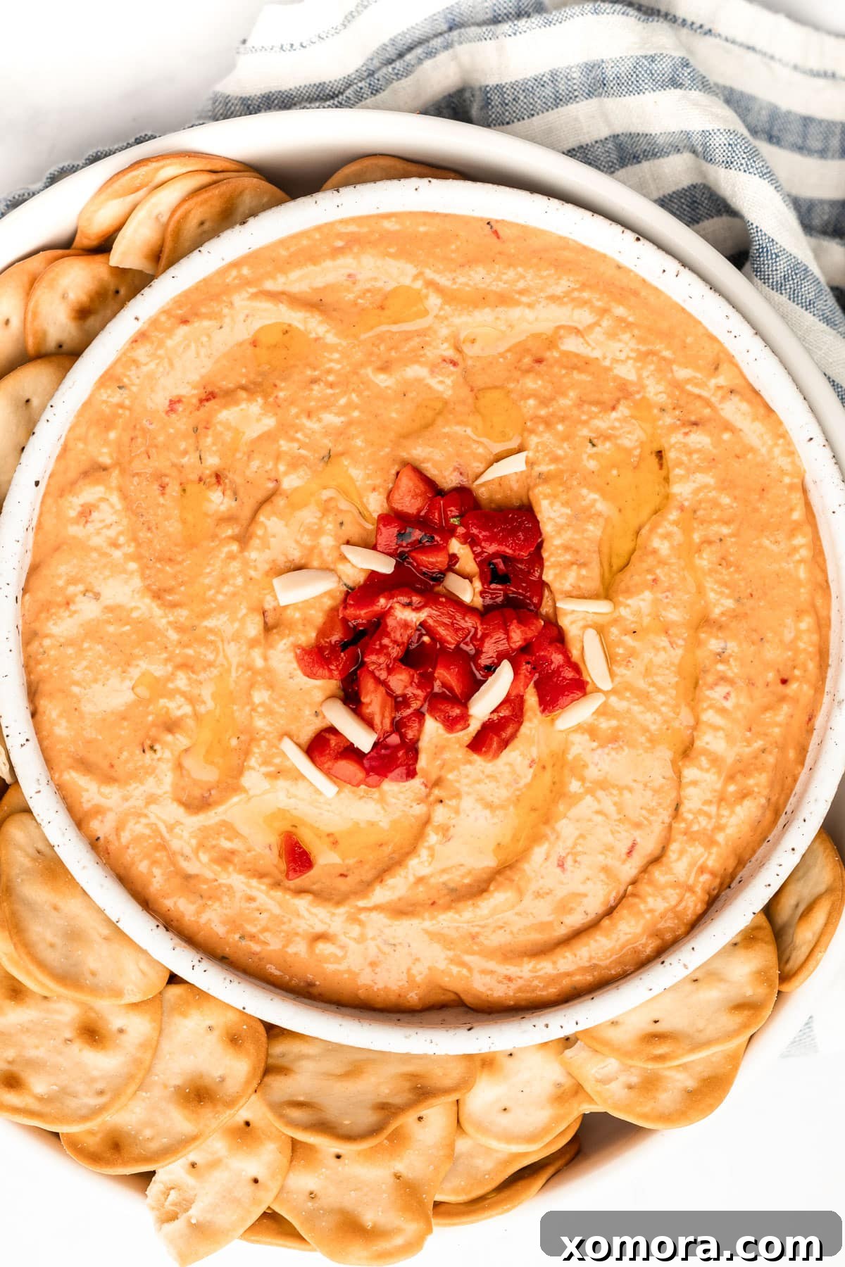 Fire-Kissed Pepper Hummus 2 A vibrant bowl of roasted red pepper hummus, garnished with a swirl of olive oil, fresh parsley, and a sprinkle of paprika.