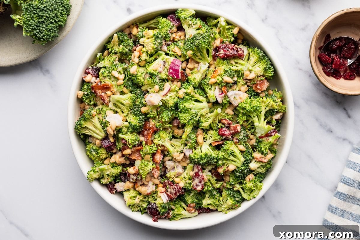 A large serving bowl filled with the freshly made Easy Crunchy Parmesan Broccoli Salad, ready to be served.