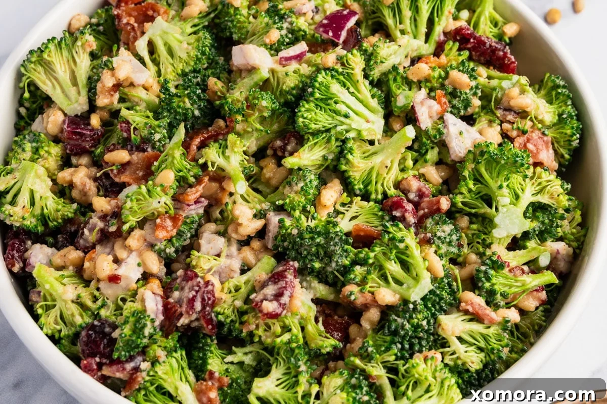 A closer view of the Easy Crunchy Parmesan Broccoli Salad in a white bowl, highlighting the rich colors and textures.