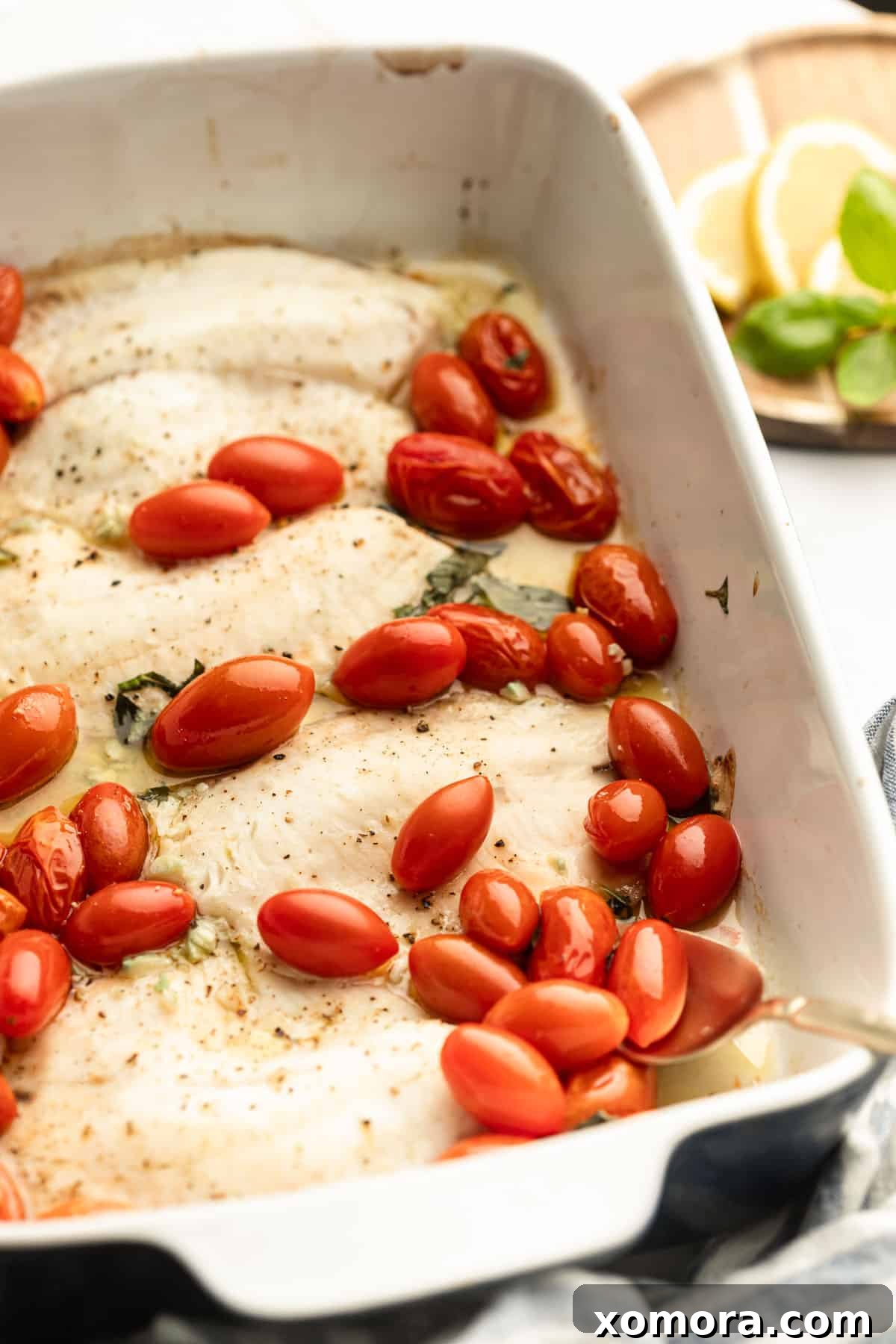 Sun Kissed Flounder with Lemon and Tomatoes 2 Freshly baked flounder fillets with lemon slices and grape tomatoes in a baking dish