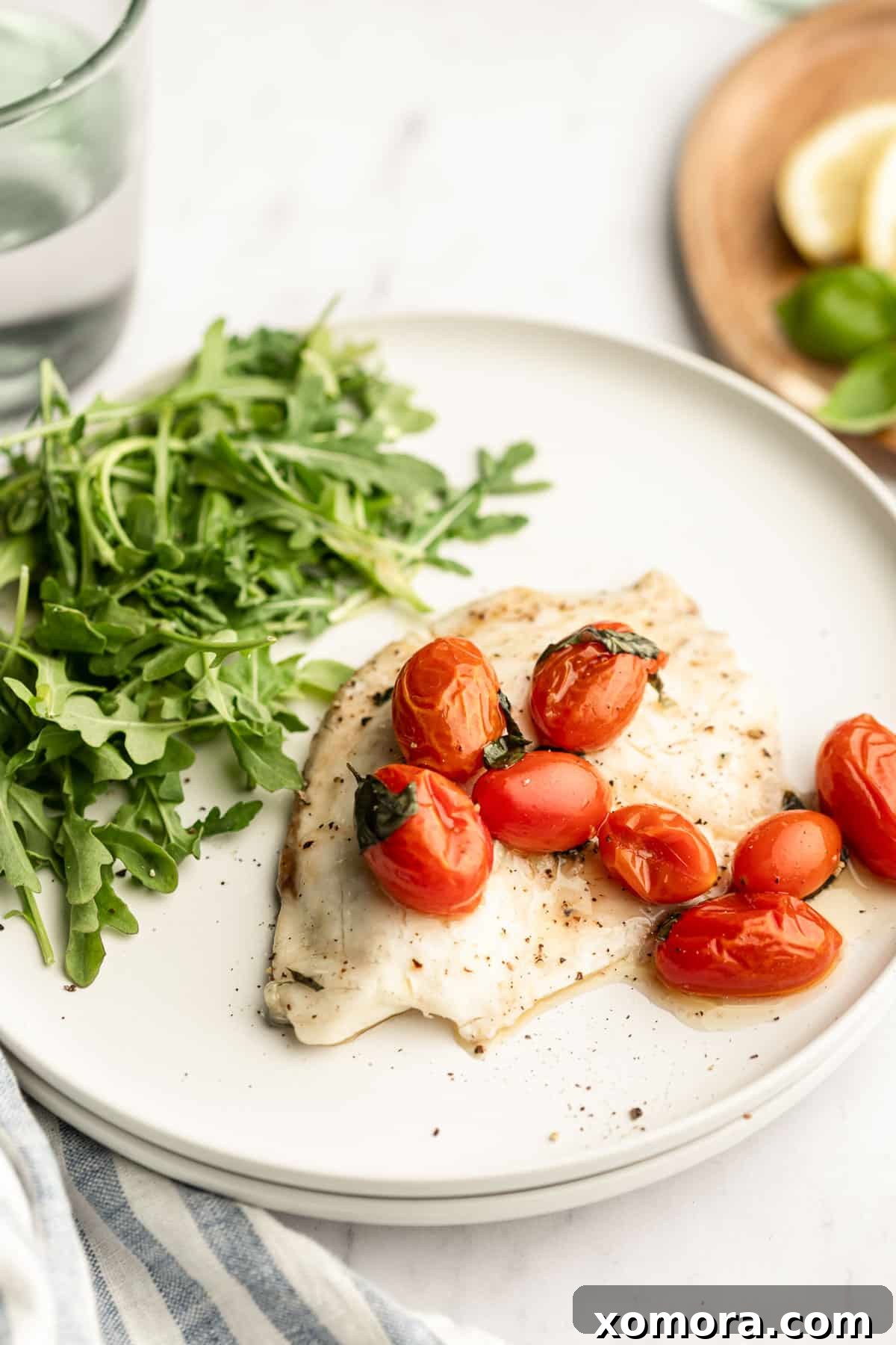 Sun Kissed Flounder with Lemon and Tomatoes 3 Close-up of baked flounder with grape tomatoes and lemon slices in a baking dish