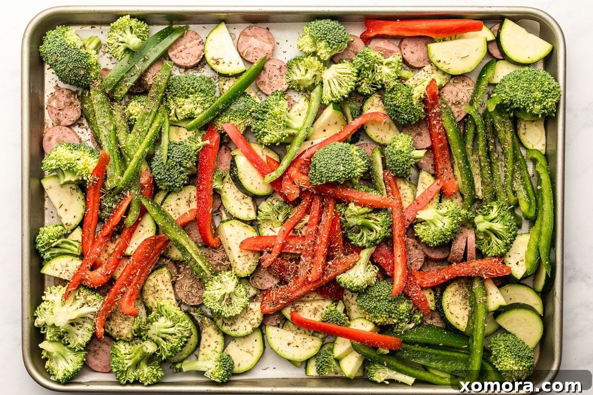 One Pan Sausage Zucchini Broccoli Dinner 3 Close-up of roasted sausage, zucchini, broccoli, and bell pepper on a sheet pan.