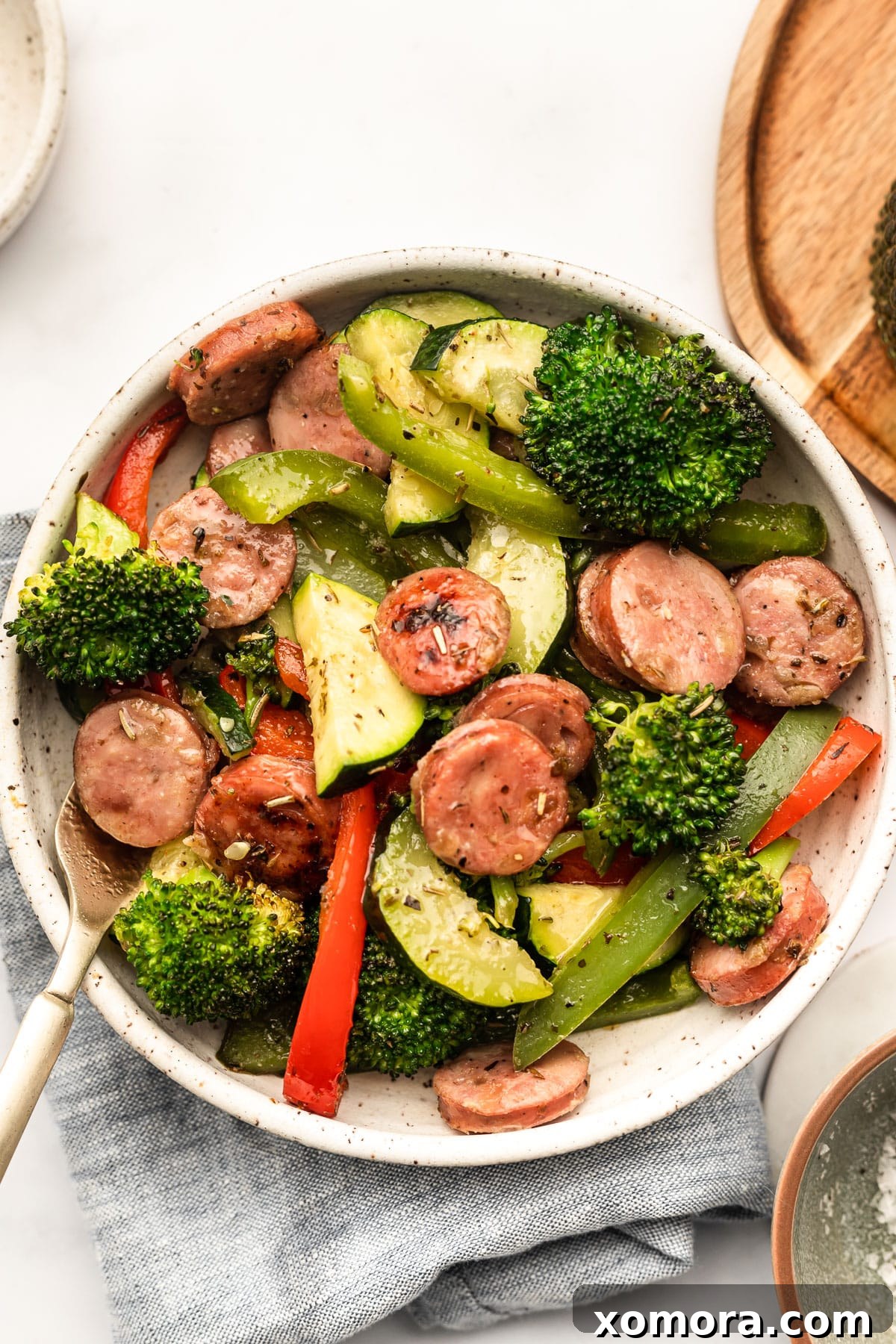 One Pan Sausage Zucchini Broccoli Dinner 5 Another overhead shot of the finished sheet pan dinner with a serving spoon.
