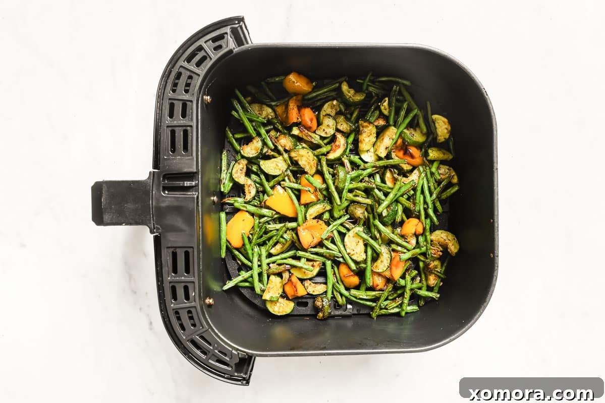 Crispy Air Fryer Sausage and Roasted Vegetables 4 Air fryer basket filled with seasoned sausage and vegetables