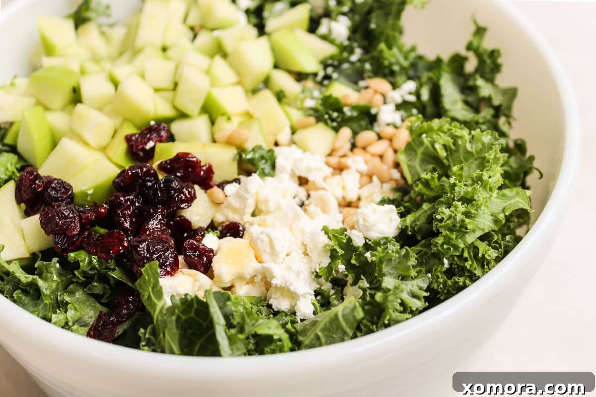 Close-up of the Easy Kale Salad ingredients being mixed in a large bowl, showcasing the fresh texture.