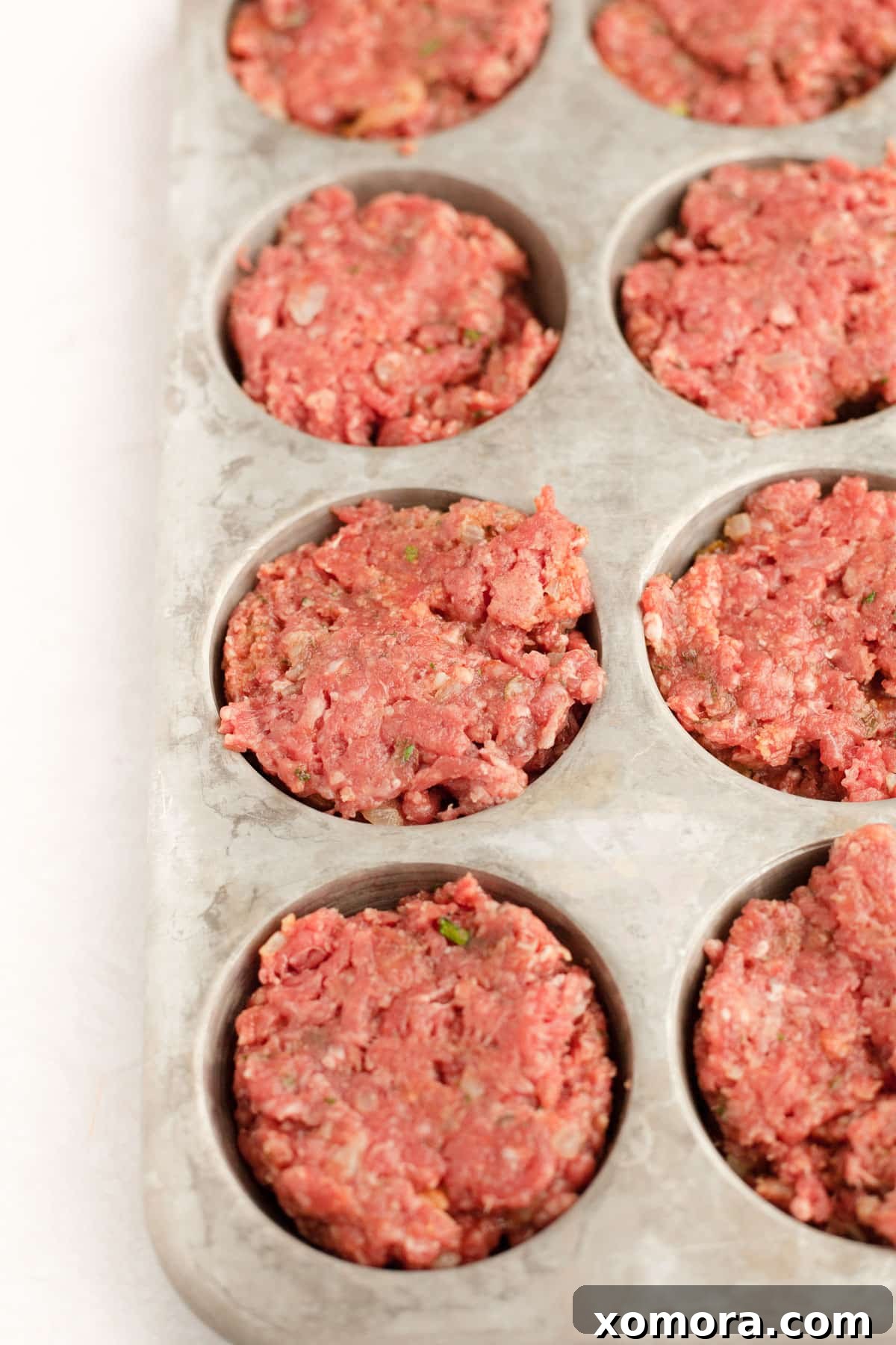 Savory Meatloaf Cups 4 A bowl of seasoned ground beef mixture, ready to be scooped into a muffin tin for meatloaf muffins.