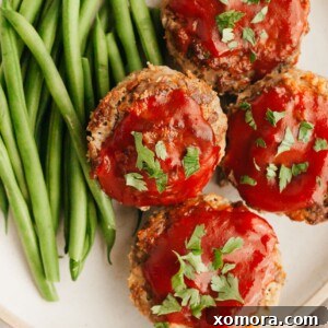 Savory Meatloaf Cups 7 A top-down view of several baked meatloaf muffins with a shiny ketchup glaze.