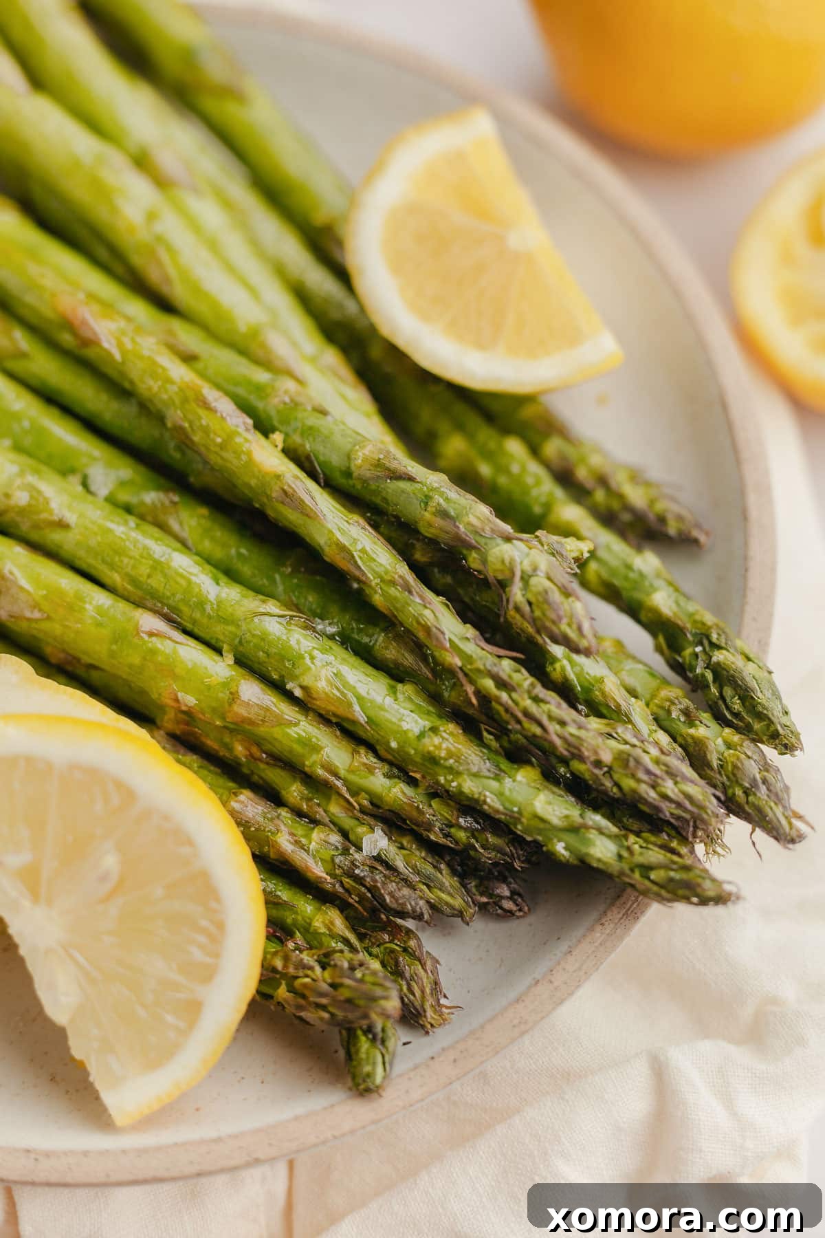 Perfectly cooked asparagus stalks in an air fryer basket, ready to serve.