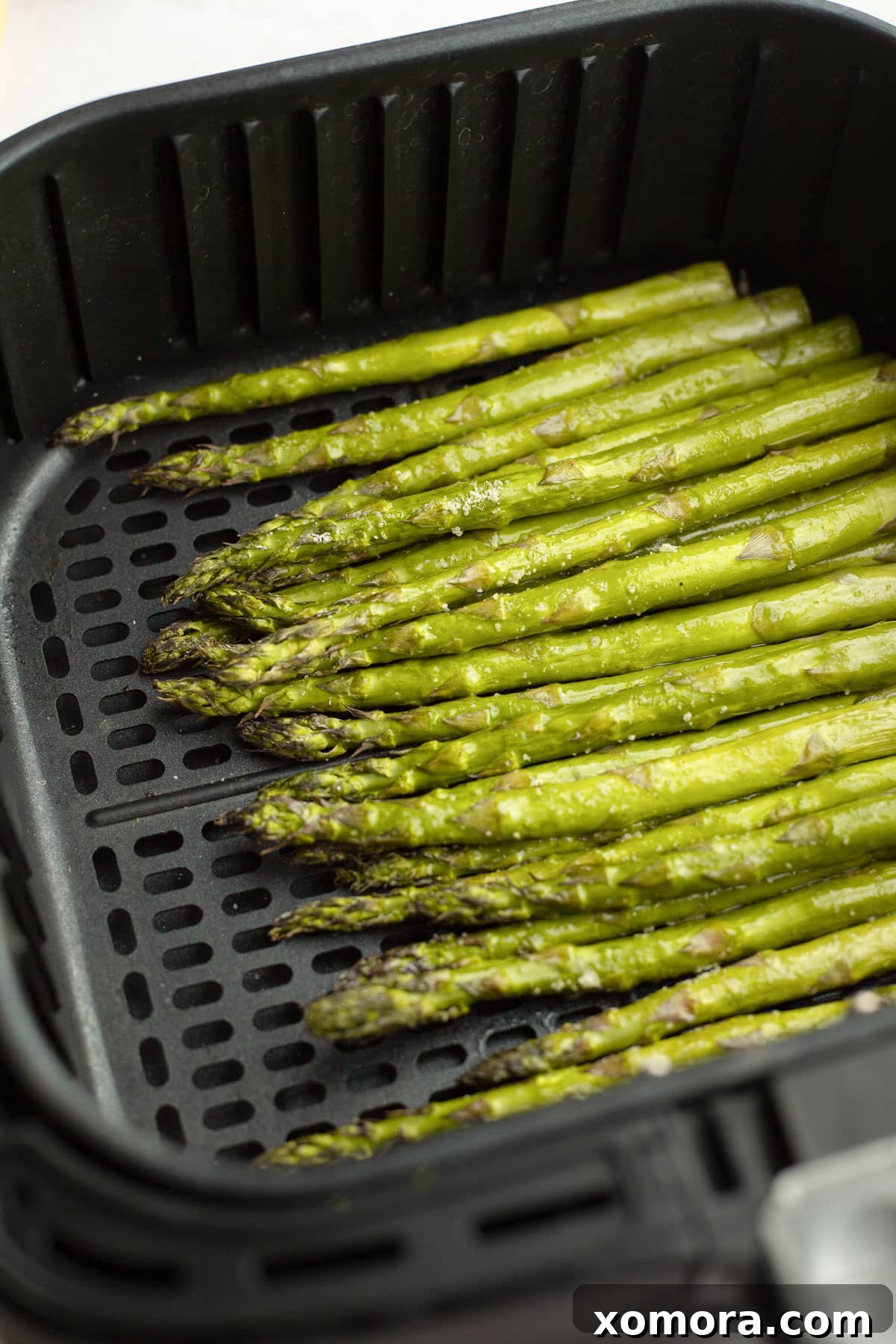 Freshly prepped asparagus stalks with their woody ends removed, ready for seasoning.