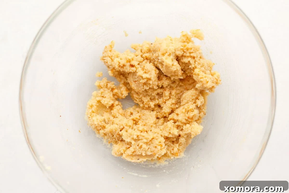 Zesty Orange Almond Delights 3 Close-up shot of the raw orange almond cookie dough balls before baking, showing the texture and orange zest flecks.
