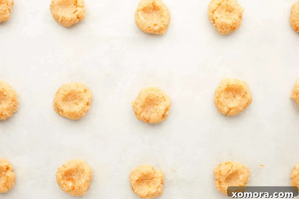 Zesty Orange Almond Delights 4 Baked orange almond cookies cooling on a wire rack before glazing, showing their golden-brown edges.