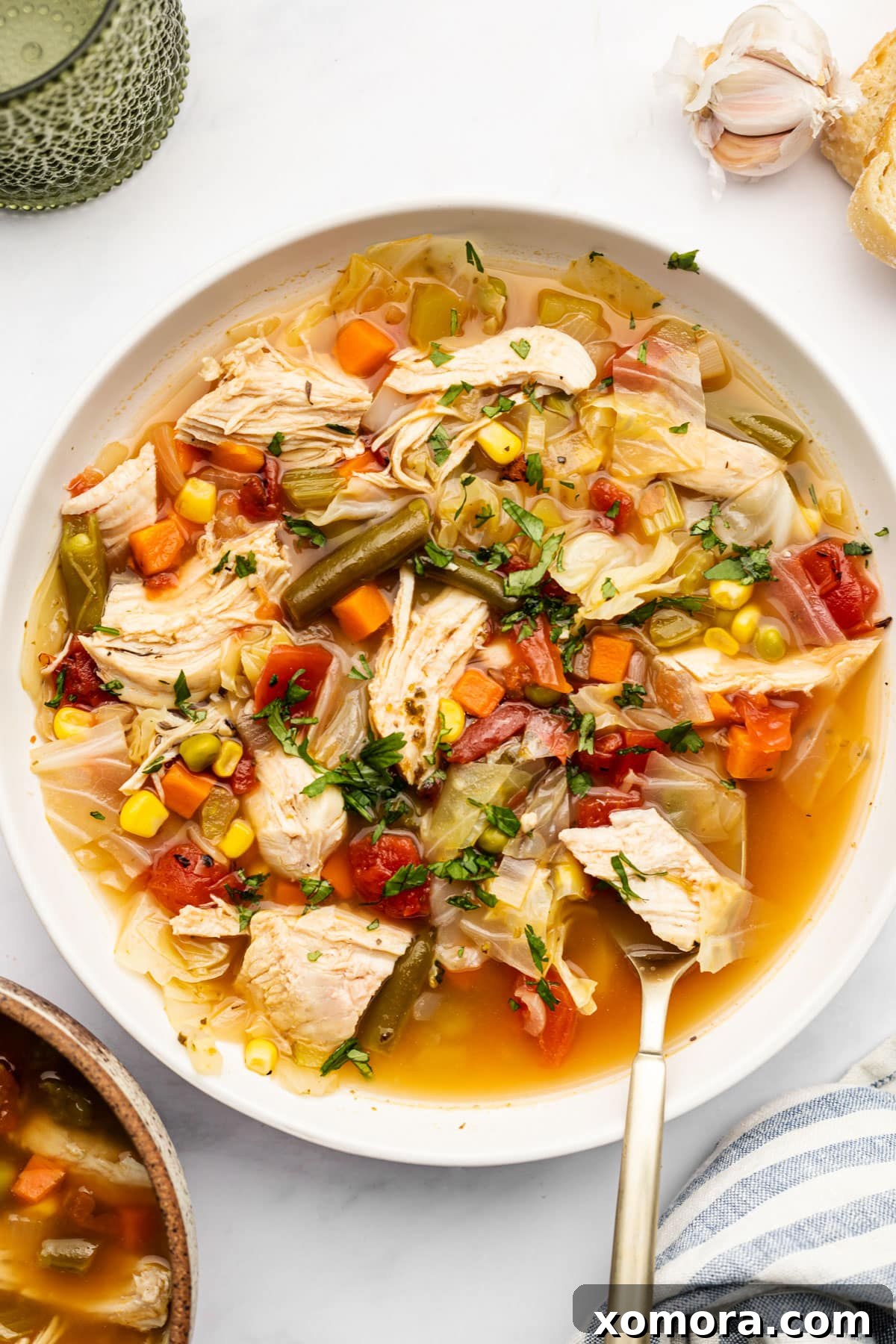 A steaming bowl of Healthy Chicken Vegetable Soup, garnished with fresh parsley.