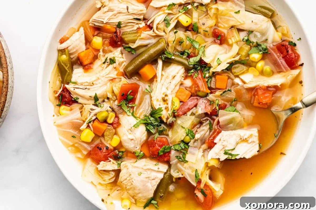 A container of prepped chicken vegetable soup, ready for storage.