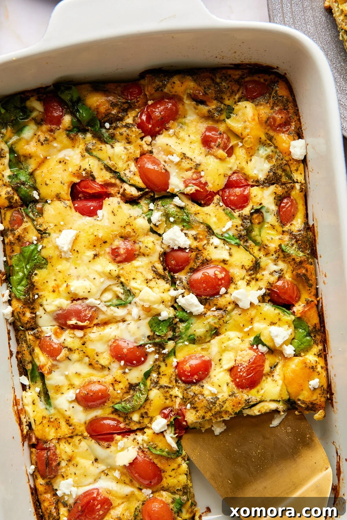 A beautifully baked low carb feta breakfast casserole, golden brown and garnished with fresh herbs, ready to be served.