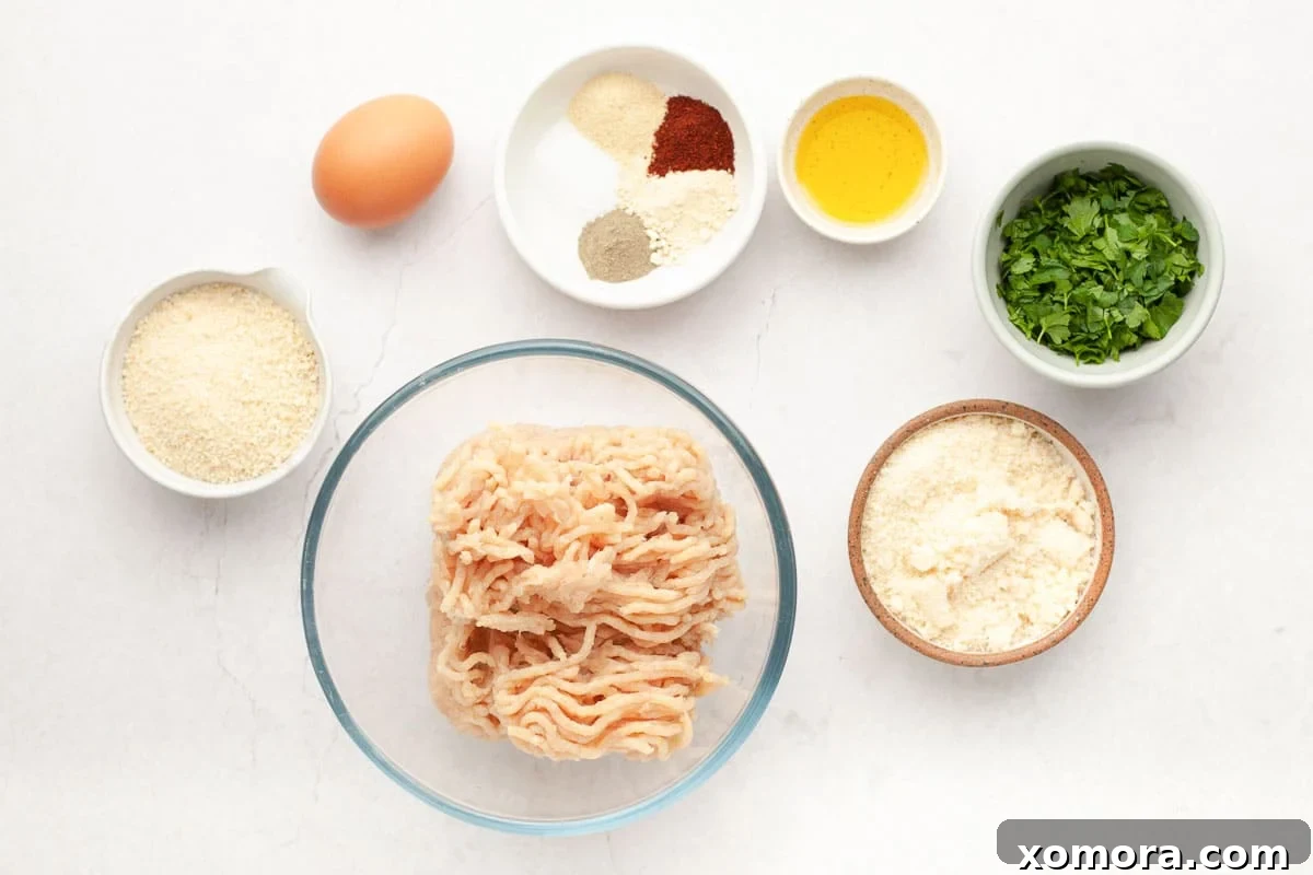 Savory Baked Parmesan Chicken Meatballs 3 Baked parmesan chicken meatballs in a serving bowl with fresh parsley