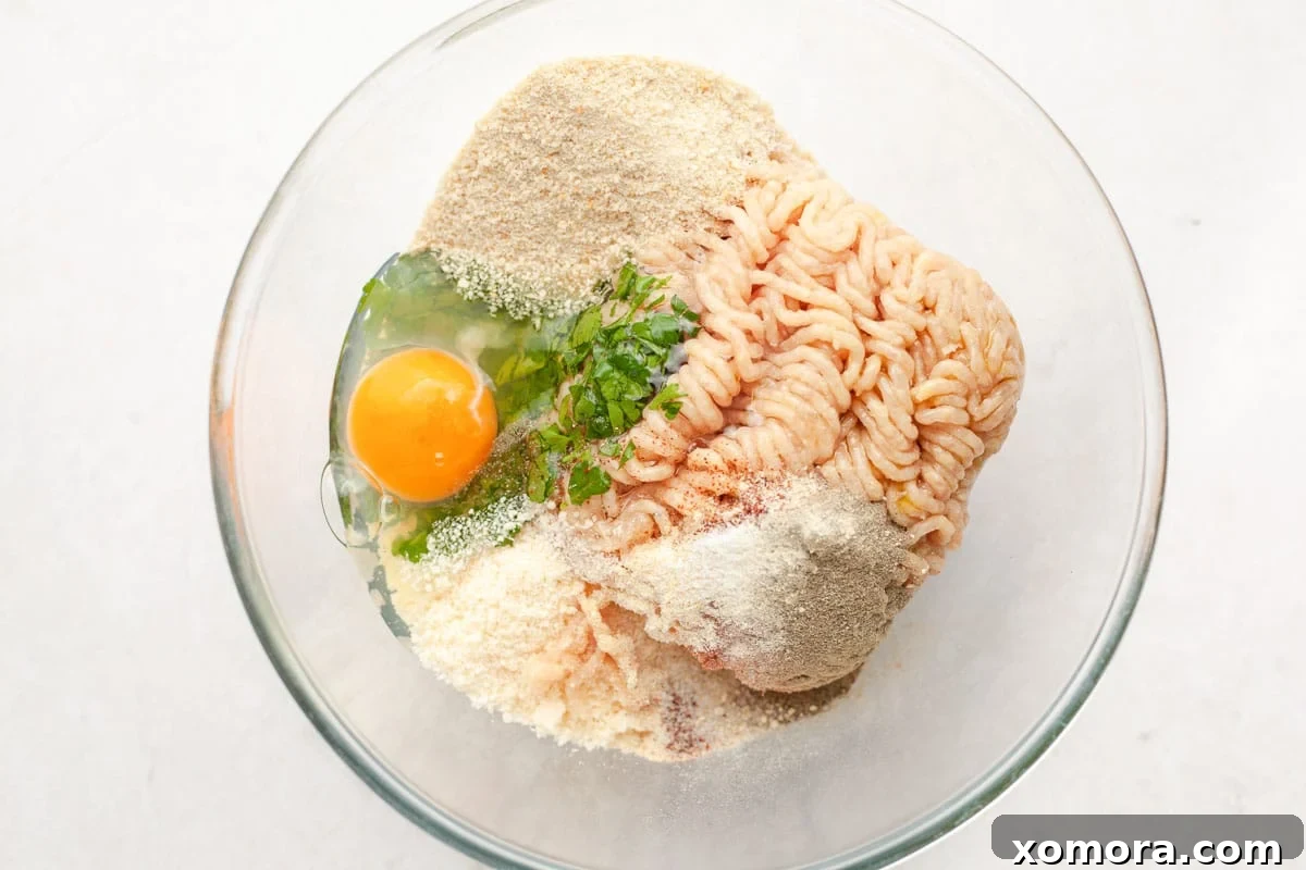 Savory Baked Parmesan Chicken Meatballs 4 Mixing bowl with ground chicken and ingredients for meatballs