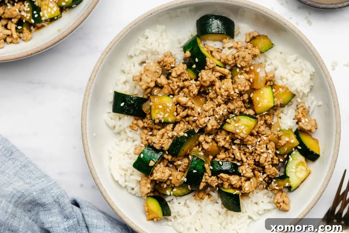 Flavorful Ground Chicken Zucchini Stir-Fry 6 The full spread of Ground Chicken and Zucchini Stir Fry, with rice, garnishes, and chopsticks.