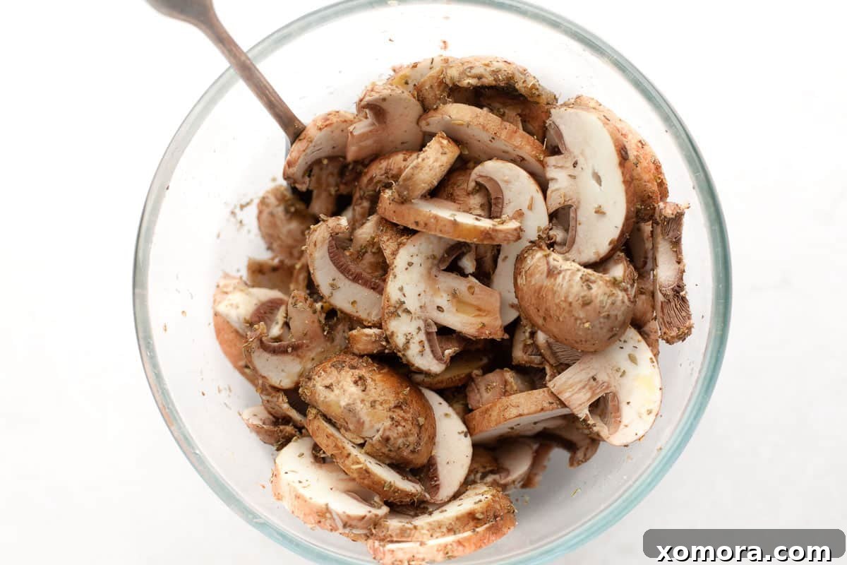 Simple Air Fryer Mushroom Perfection 3 Air fryer basket filled with seasoned sliced mushrooms, ready for cooking