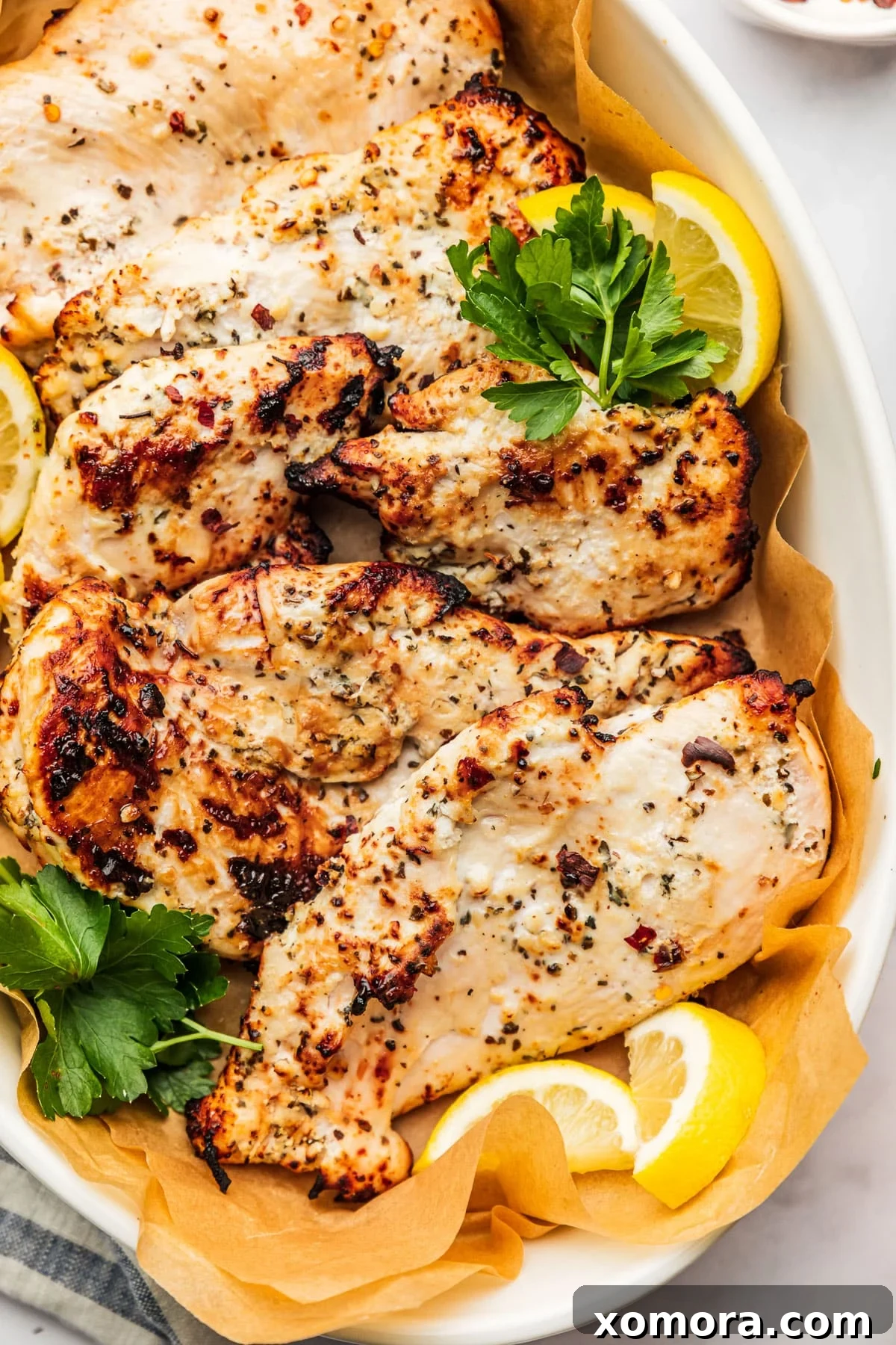 Golden Air Fryer Yogurt Chicken 2 Yogurt Marinated Air Fryer Chicken, cooked and sliced, served with fresh herbs.