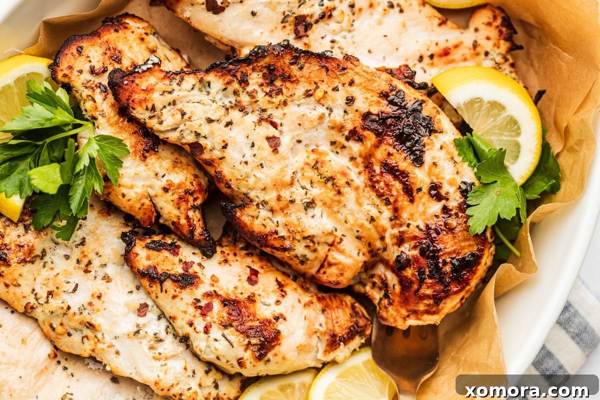 Golden Air Fryer Yogurt Chicken 5 Cooked yogurt marinated chicken breast slices on a wooden cutting board.
