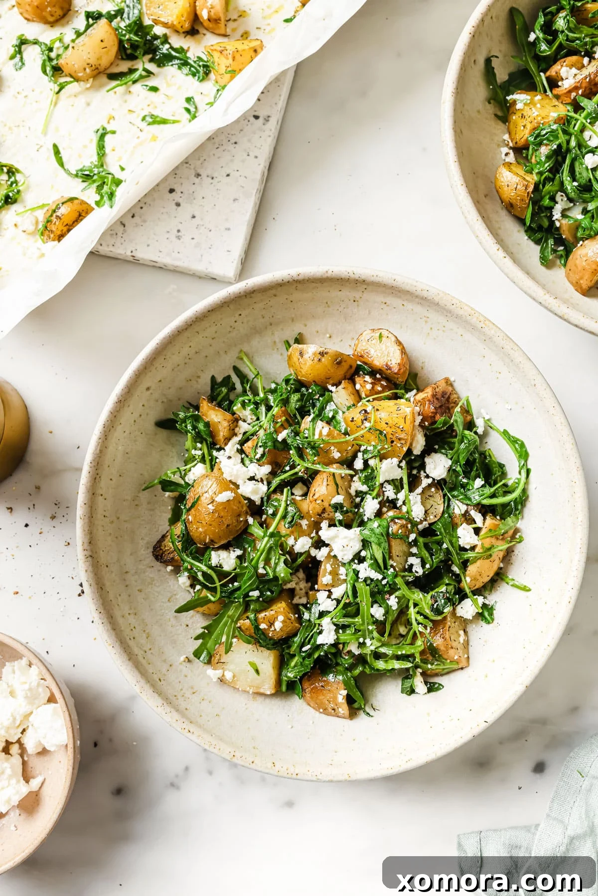 Close-up of the finished salad in a serving bowl, garnished with fresh herbs