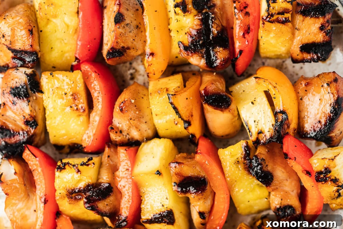 Hawaiian Chicken Pineapple Kabobs 4 A close-up of chicken, pineapple, and bell pepper chunks expertly threaded onto skewers, ready for grilling