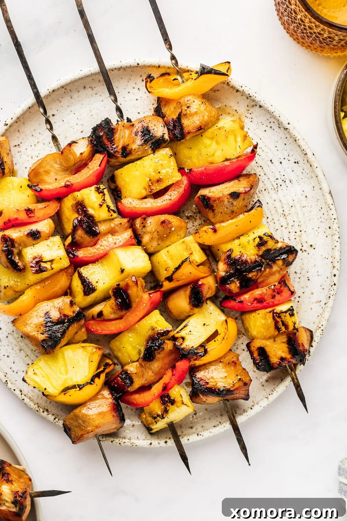 Hawaiian Chicken Pineapple Kabobs 5 Plated chicken and pineapple kabobs garnished with fresh cilantro, ready to be served as a healthy and vibrant meal