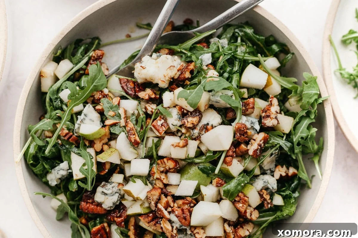 Crisp Pear Arugula Salad with Sweet Candied Pecans 5 A large bowl of tossed Arugula Pear Salad with Candied Pecans and Gorgonzola, ready to be enjoyed.