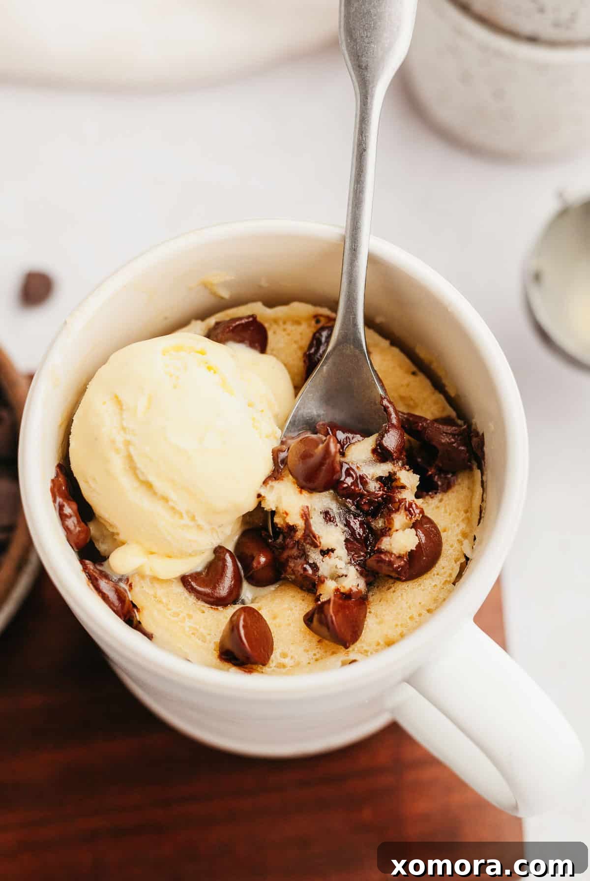Quick Gluten-Free Chocolate Chip Mug Treat 2 A perfectly baked gluten-free chocolate chip mug cake with melted chocolate chips on top, served in a white mug.