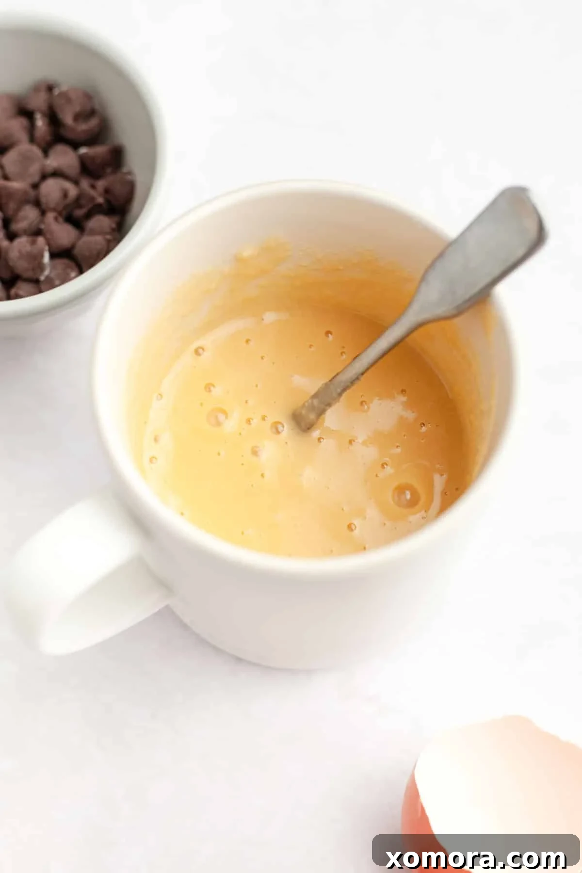 Quick Gluten-Free Chocolate Chip Mug Treat 5 A close-up shot of paleo baking flour being poured from a measuring cup into a mixing bowl.