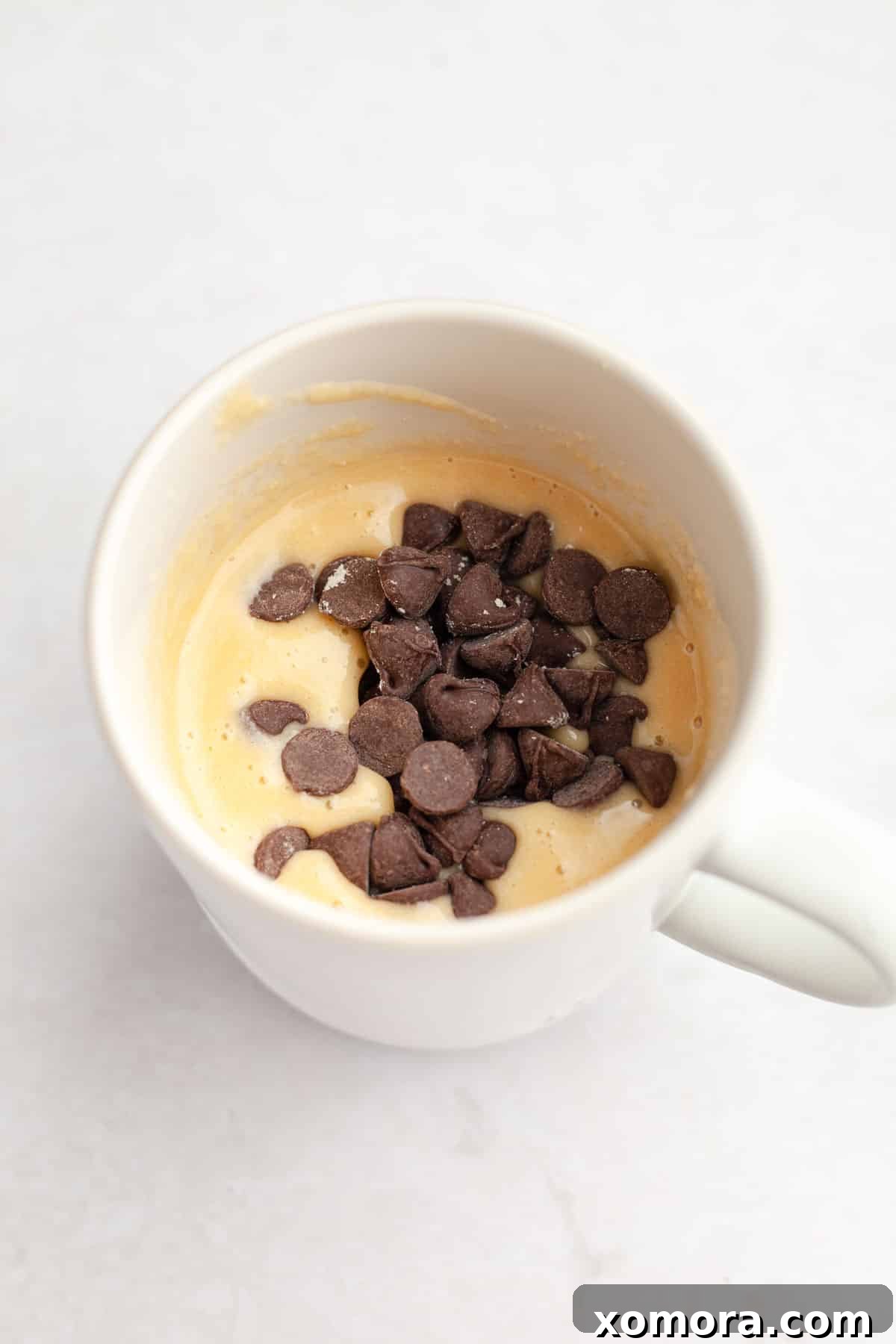 Quick Gluten-Free Chocolate Chip Mug Treat 6 A delectable gluten-free chocolate chip mug cake, topped with fresh raspberries, ready to be enjoyed.