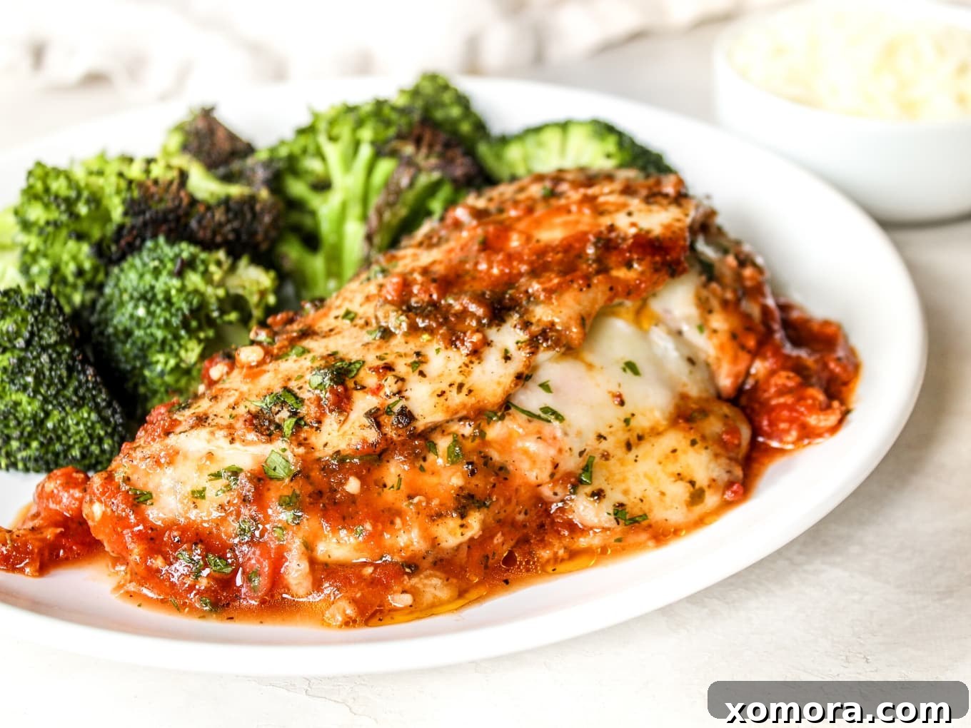 Mozzarella Stuffed Chicken, oozing with cheese in a tomato sauce.