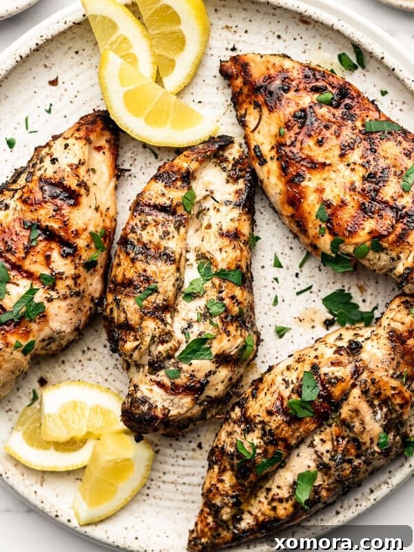 Lemon Herb Grilled Chicken, with lemon slices and fresh herbs.