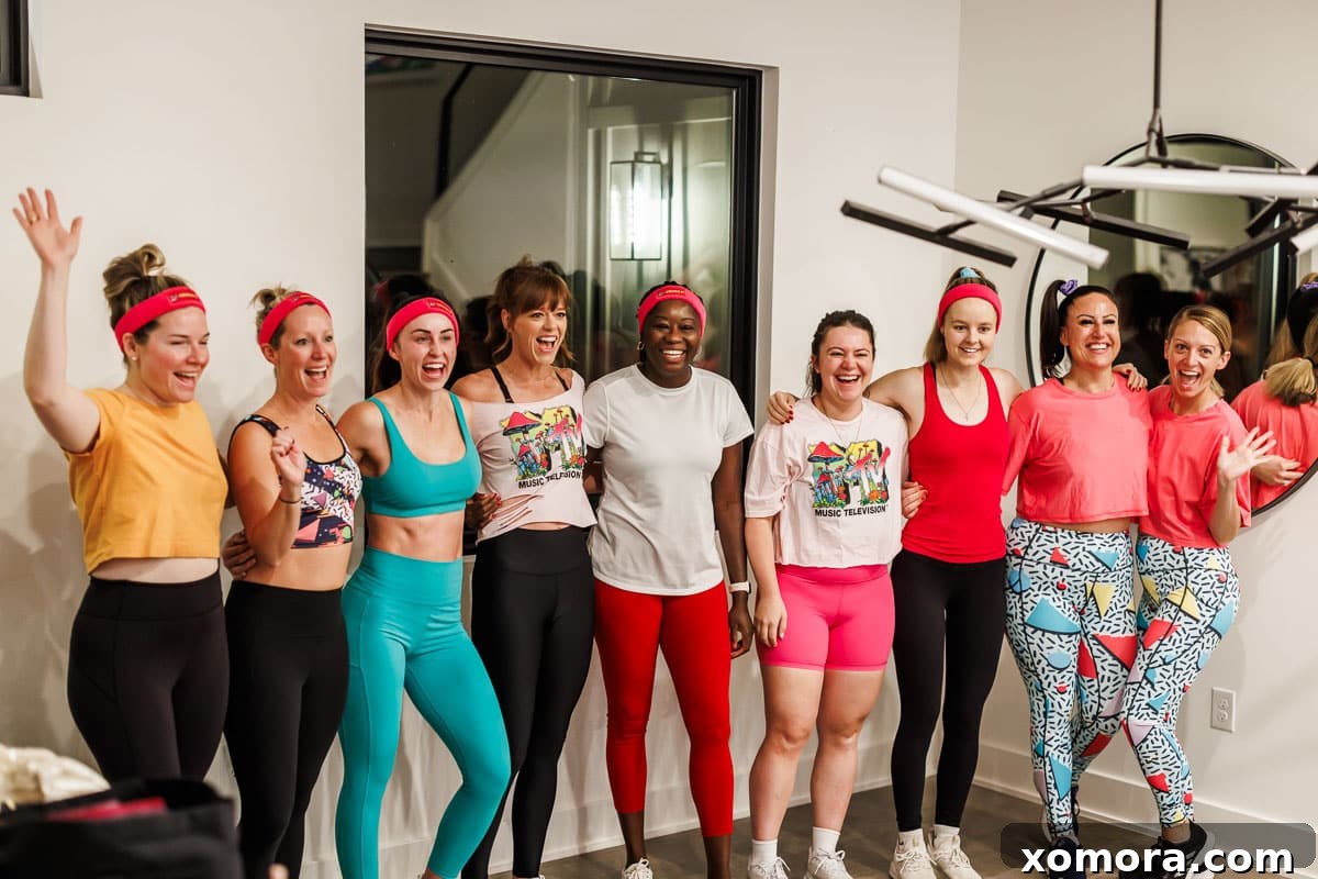A group photo of food bloggers enthusiastically participating in a 90s-themed workout session, possibly with Dave's Killer Bread products in the background.