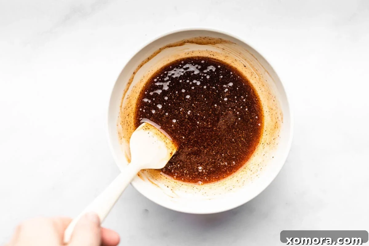 Sweet Heat Honey Drizzle 5 A close-up of hot honey being drizzled from a spoon, showing its thick, glossy texture.